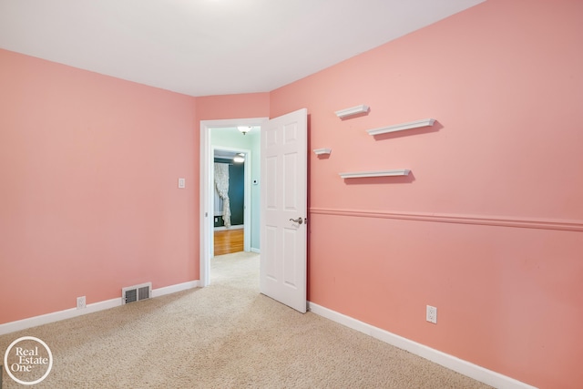 unfurnished room with baseboards, carpet, and visible vents