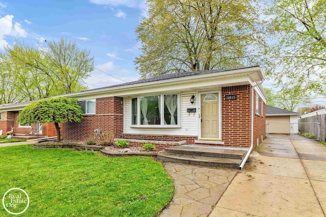 ranch-style house featuring brick siding, fence, and a front lawn