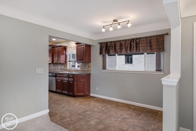 kitchen featuring a sink, baseboards, decorative backsplash, and stainless steel dishwasher