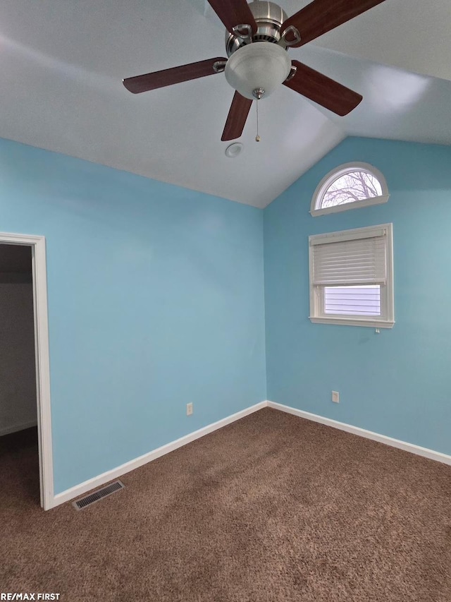 carpeted empty room featuring visible vents, a ceiling fan, baseboards, and lofted ceiling