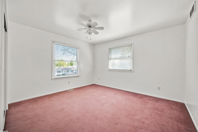 spare room featuring carpet flooring, a ceiling fan, baseboards, and visible vents