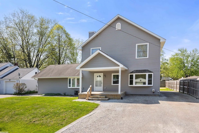 traditional-style home featuring covered porch, fence, a chimney, and a front lawn