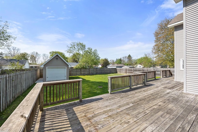 wooden terrace with a fenced backyard, an outbuilding, a yard, and a detached garage