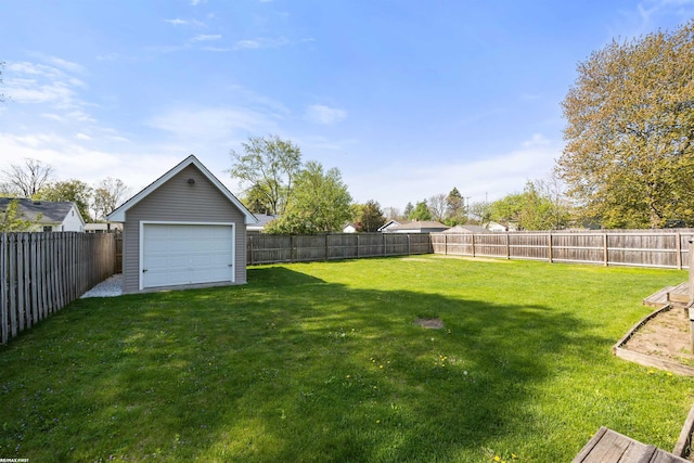 view of yard with a fenced backyard and a garage