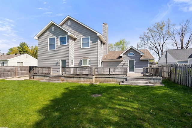 rear view of property with a lawn, a fenced backyard, a chimney, and a deck