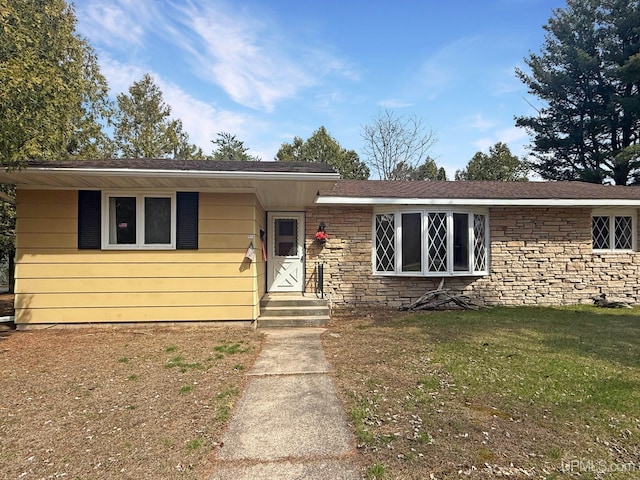 single story home with a front lawn and stone siding