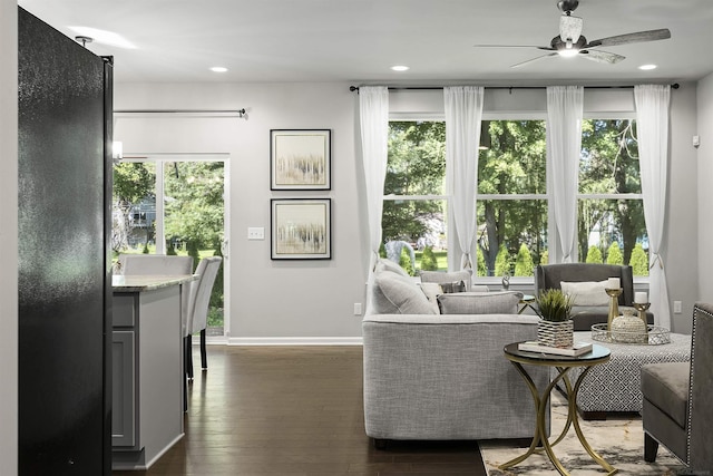 living area with baseboards, a ceiling fan, dark wood finished floors, and recessed lighting