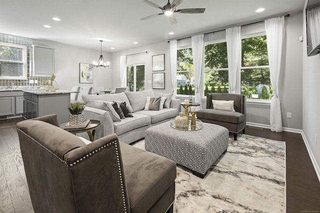 living area with recessed lighting, ceiling fan with notable chandelier, and wood finished floors