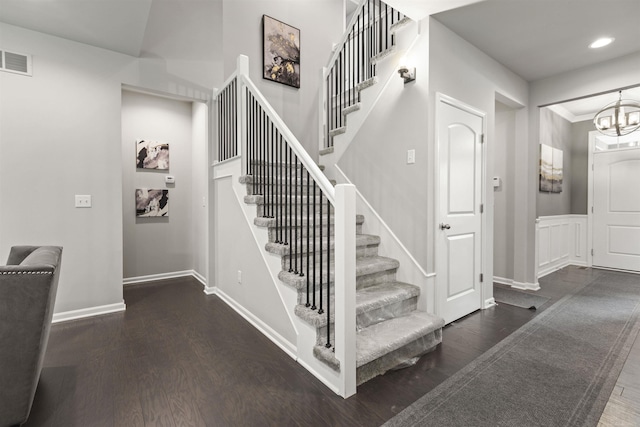 staircase with visible vents, wood finished floors, baseboards, recessed lighting, and a chandelier