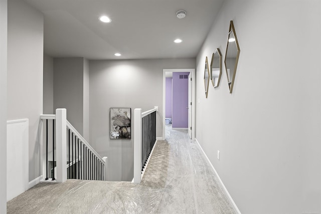 corridor with recessed lighting, baseboards, and an upstairs landing