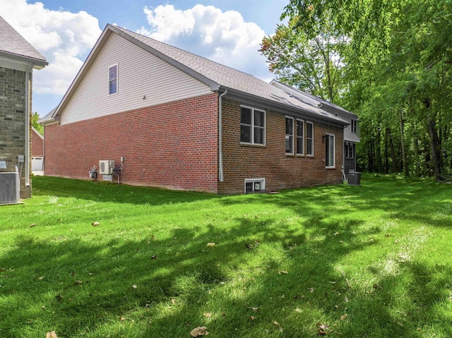 view of home's exterior featuring a yard, brick siding, and cooling unit