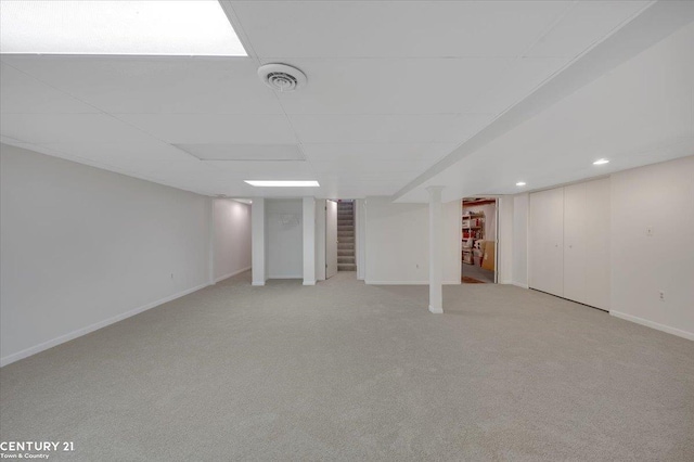 finished basement with light carpet, stairs, recessed lighting, baseboards, and visible vents