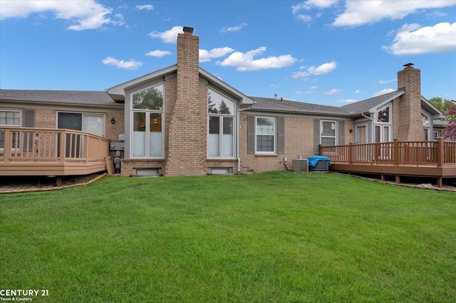 rear view of house featuring a yard, brick siding, and a wooden deck