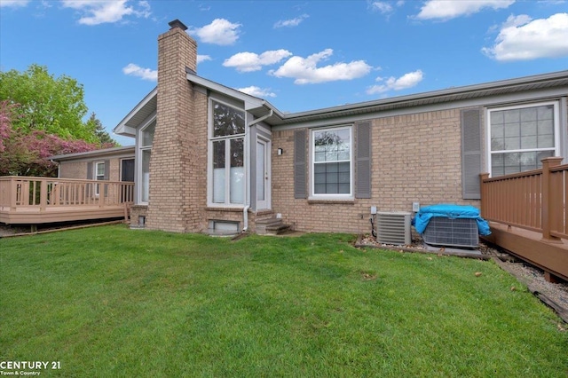 back of house with a wooden deck, a chimney, brick siding, central AC unit, and entry steps