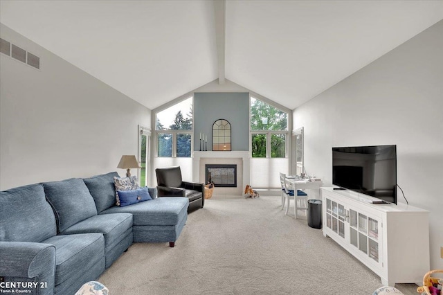 living room featuring carpet flooring, a glass covered fireplace, lofted ceiling with beams, and visible vents