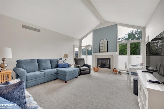 living room with visible vents, beam ceiling, light carpet, high vaulted ceiling, and a tiled fireplace