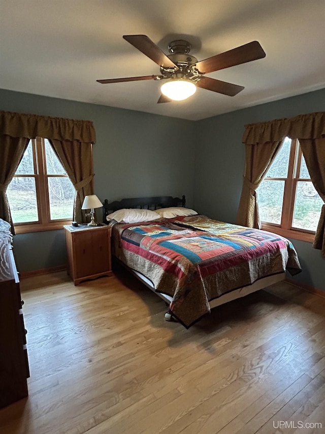bedroom with a ceiling fan and light wood-type flooring