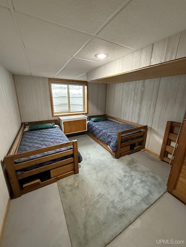 bedroom featuring wooden walls