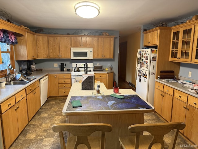 kitchen with a kitchen island, a sink, light countertops, glass insert cabinets, and white appliances