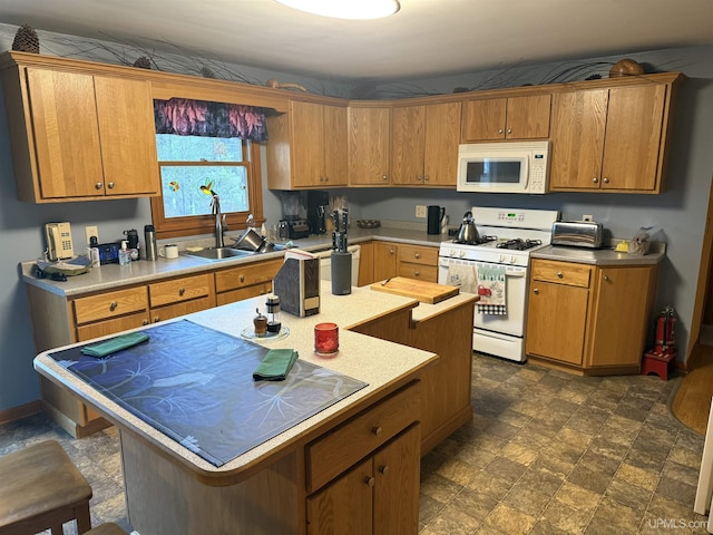 kitchen featuring white appliances, a center island, light countertops, a sink, and stone finish flooring