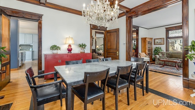 dining area featuring beamed ceiling, a notable chandelier, light wood-style floors, ornamental molding, and coffered ceiling