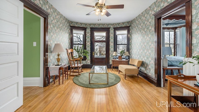 entrance foyer with wood-type flooring, a ceiling fan, baseboards, and wallpapered walls