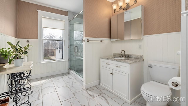bathroom with wallpapered walls, wainscoting, a stall shower, and marble finish floor