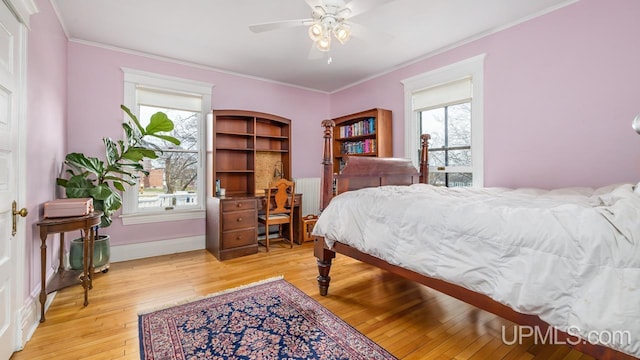 bedroom with crown molding, light wood finished floors, ceiling fan, and baseboards