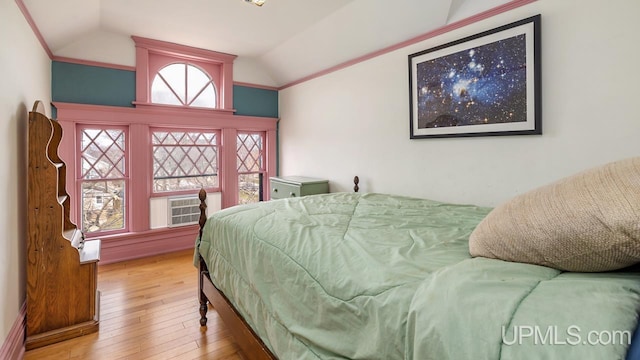 bedroom with ornamental molding, vaulted ceiling, and hardwood / wood-style floors
