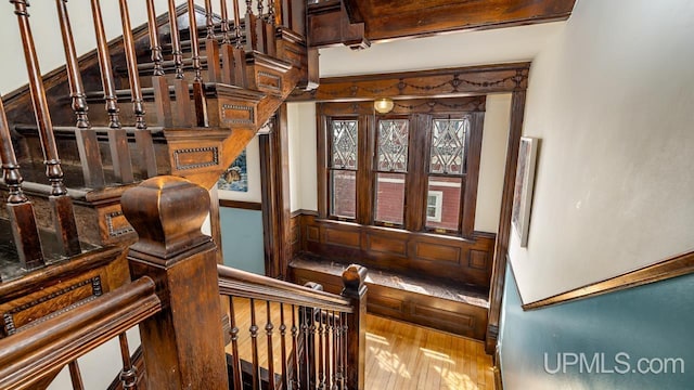 staircase with wood-type flooring and wainscoting