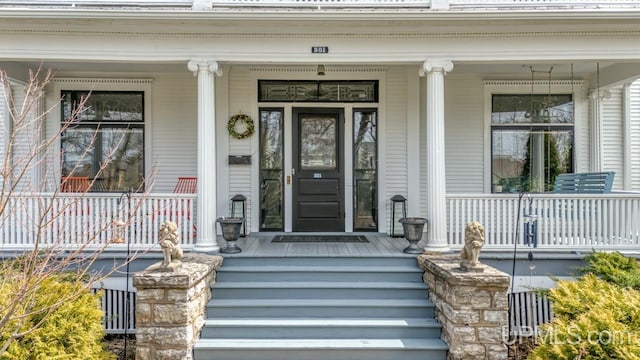 view of exterior entry featuring covered porch