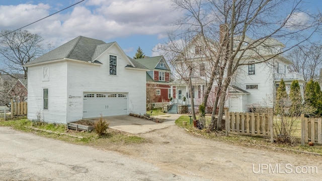 view of front of home with an attached garage, fence, and driveway