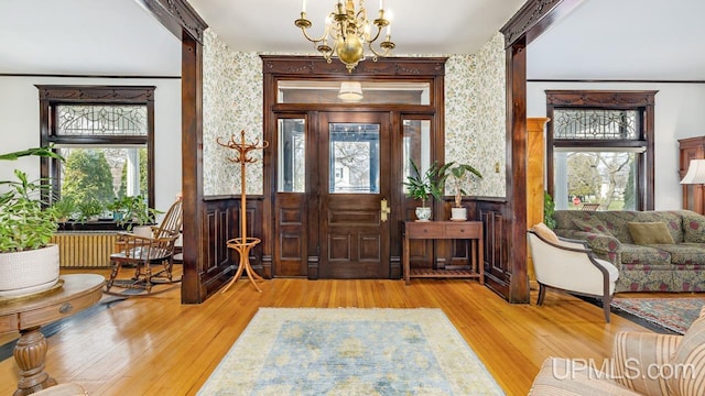 entryway featuring an inviting chandelier and wood finished floors