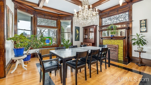 dining area with beamed ceiling, wood-type flooring, coffered ceiling, and a chandelier