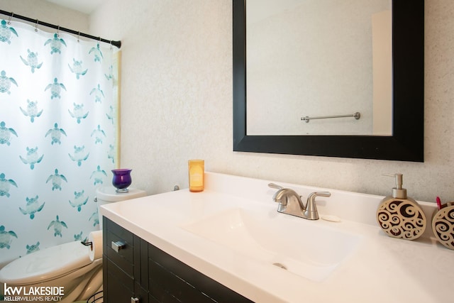 bathroom with vanity, curtained shower, and toilet