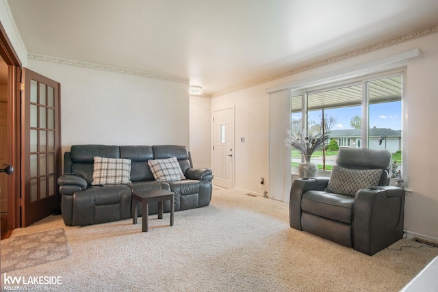 carpeted living room featuring crown molding, baseboards, and visible vents