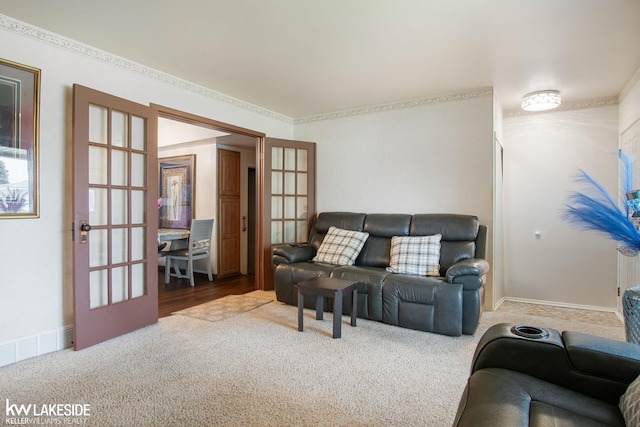 carpeted living area featuring visible vents, baseboards, crown molding, and french doors