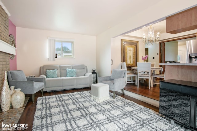 living area featuring a notable chandelier, wood finished floors, and a fireplace