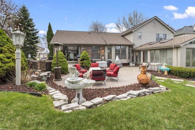 back of house featuring a sunroom, a shingled roof, a patio area, and a yard
