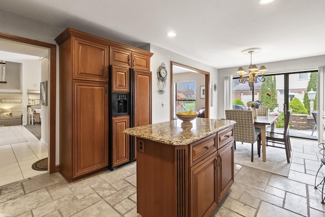 kitchen with stone tile flooring, paneled fridge, light stone countertops, and an inviting chandelier