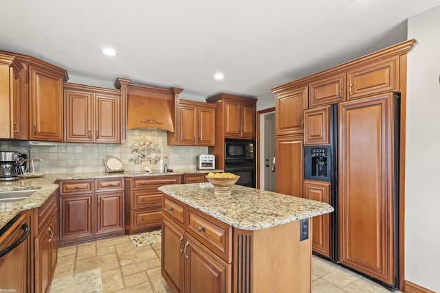 kitchen featuring a center island, backsplash, black appliances, and brown cabinetry