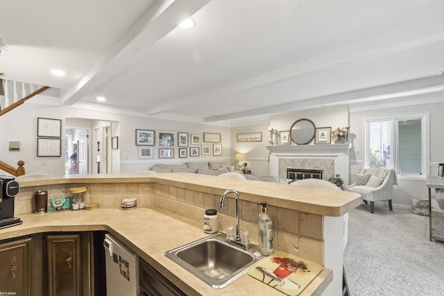 kitchen with a sink, light countertops, beam ceiling, and open floor plan