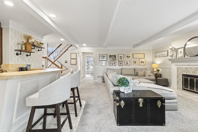 living room featuring recessed lighting, beamed ceiling, light carpet, and stairway
