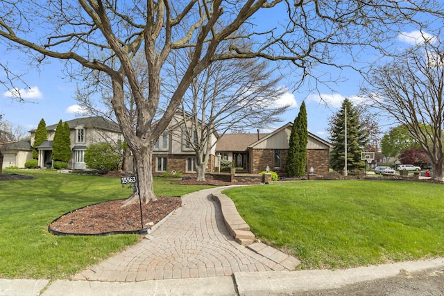 view of front of home featuring brick siding, a front lawn, and stone siding