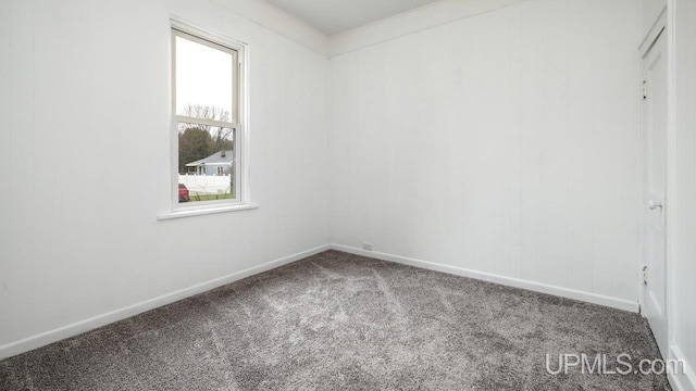 unfurnished room with baseboards, plenty of natural light, ornamental molding, and carpet flooring