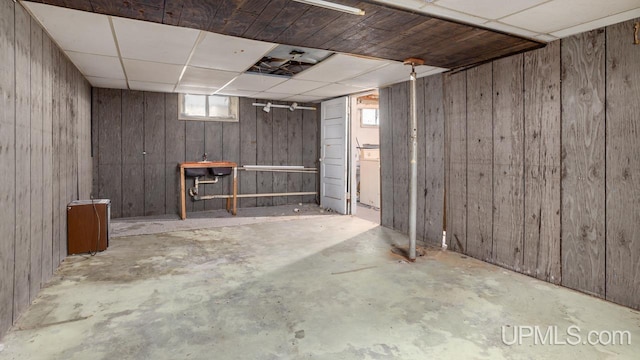 below grade area with wood walls and a paneled ceiling