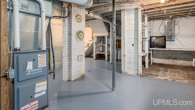 unfinished below grade area with heating unit and electric panel