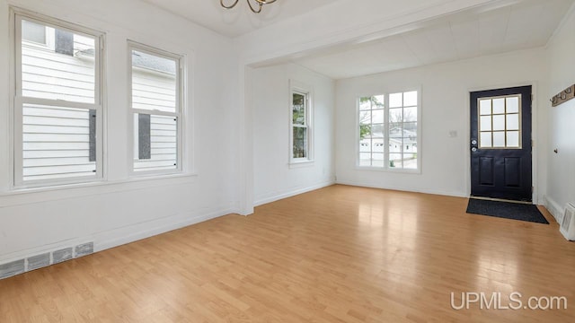 foyer entrance with light wood-style floors, baseboards, a notable chandelier, and visible vents