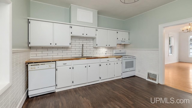 kitchen with a sink, white appliances, white cabinetry, under cabinet range hood, and visible vents