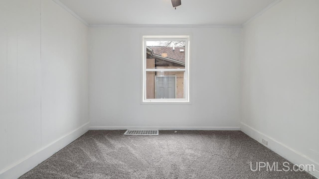 spare room featuring carpet floors, a ceiling fan, baseboards, and crown molding